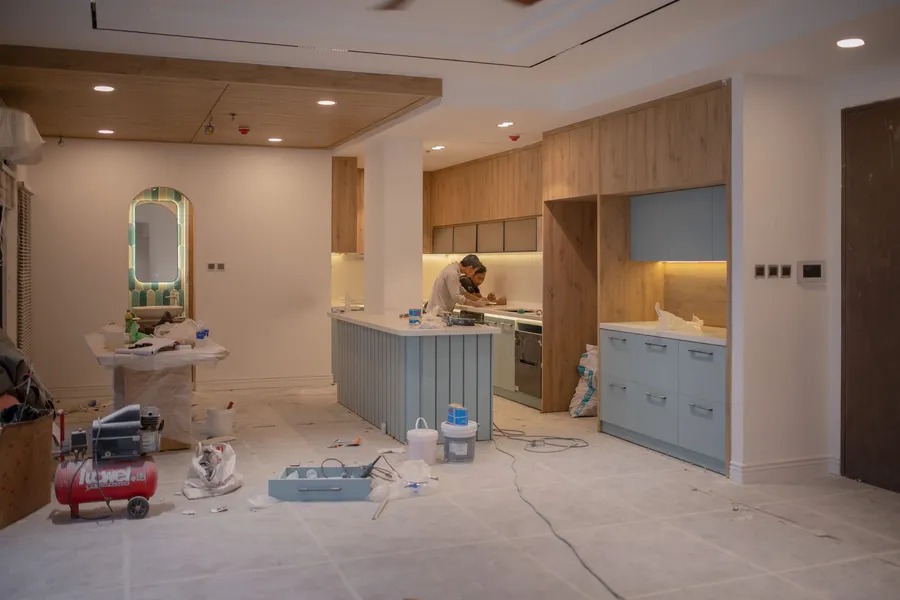 Kitchen mid-renovation with a worker and tools