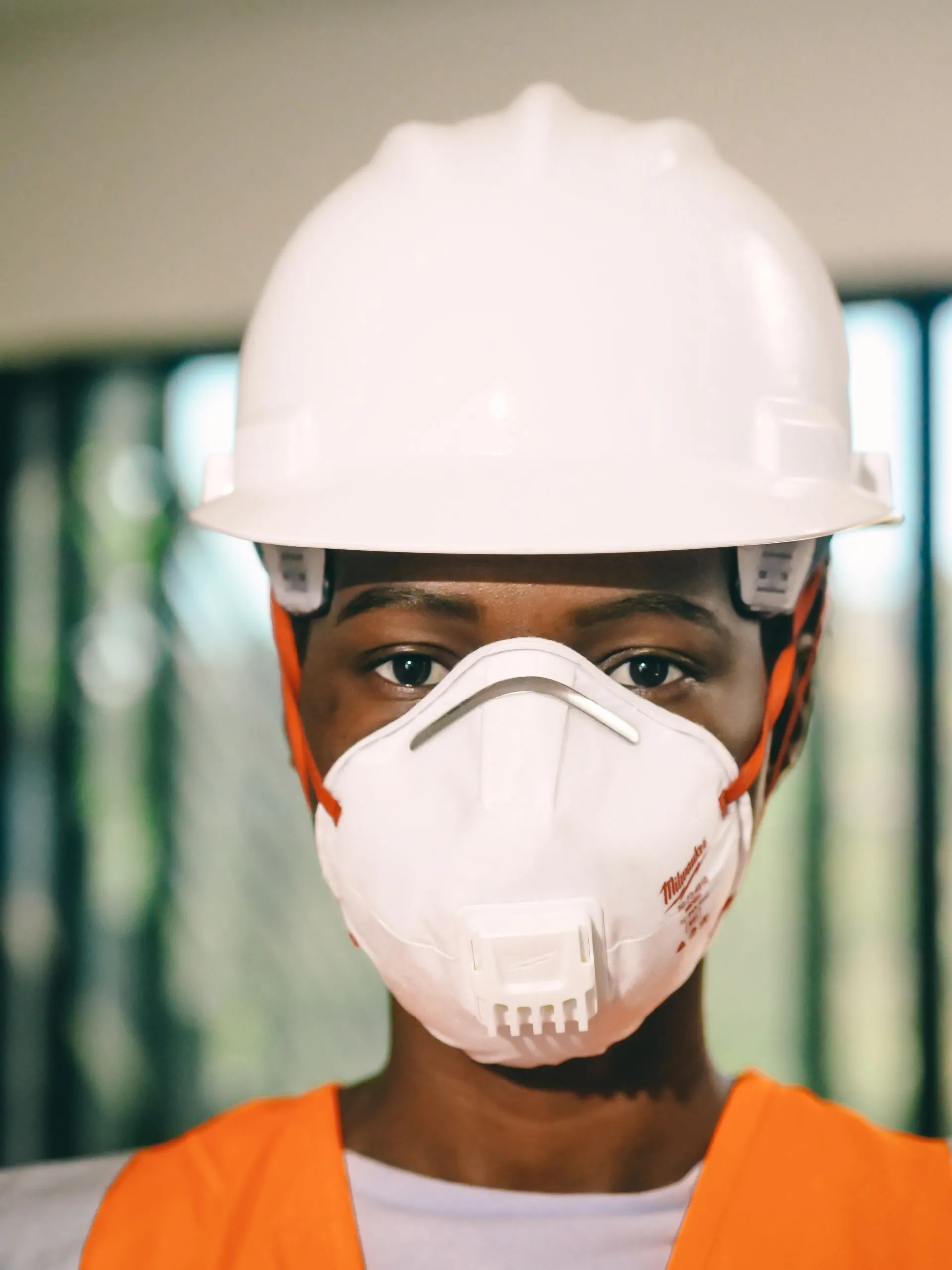 Worker in a hard hat and N95 respirator on an indoor job